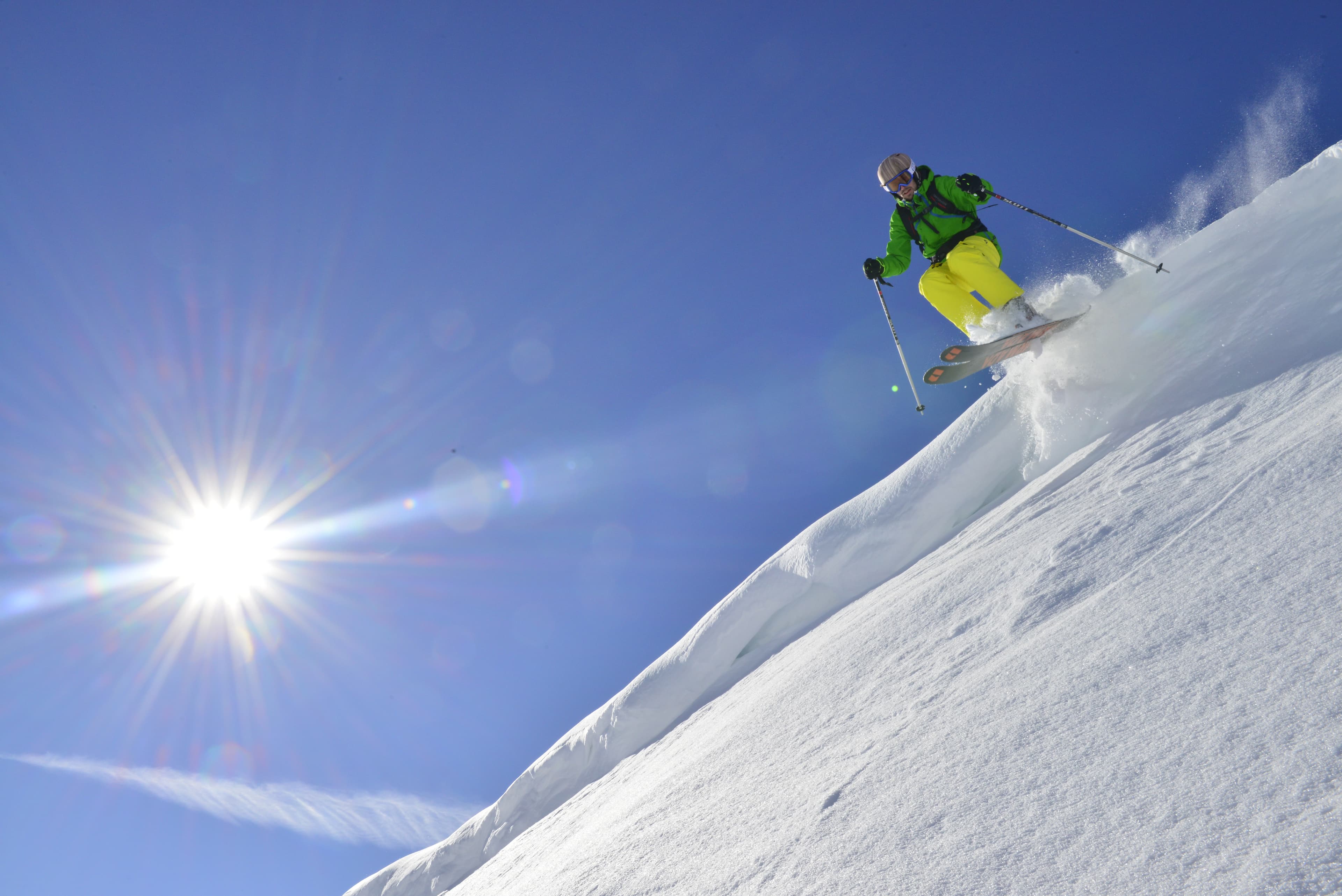 Skiier Jumping off snowy ledge at Alpbach ski resort